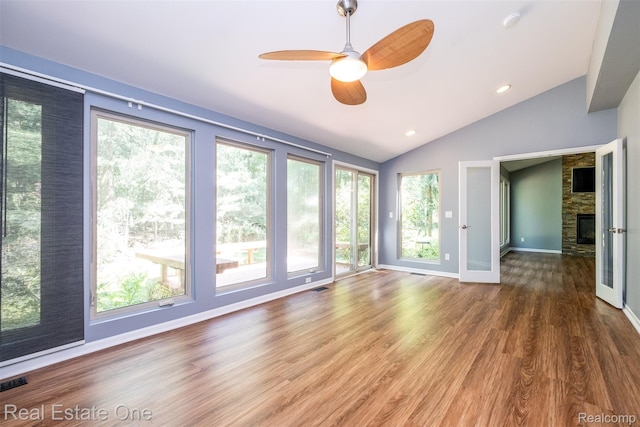 4079 Cumberland Ct, Commerce Twp, MI 48390 - empty room featuring lofted ceiling, healthy amount of natural light, ceiling fan, wood finished floors, and a fireplace