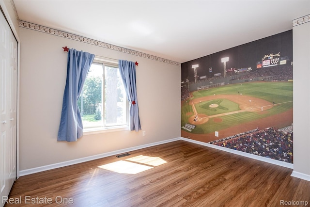 4079 Cumberland Ct, Commerce Twp, MI 48390 - unfurnished room featuring wood finished floors and golf simulator