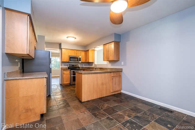 4079 Cumberland Ct, Commerce Twp, MI 48390 - kitchen featuring stainless steel appliances, stone tile flooring, a peninsula, and a ceiling fan