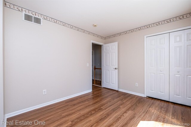 4079 Cumberland Ct, Commerce Twp, MI 48390 - unfurnished bedroom featuring wood finished floors and a closet