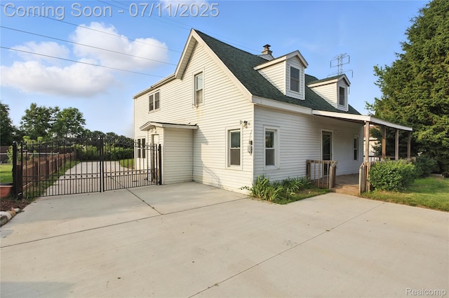 420 Wellsboro St, Walled Lake, MI 48390 - view of side of home featuring a gate, a chimney, covered porch, and driveway