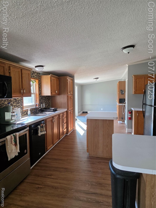 4605 Pleasant St, Clifford, MI 48727 - kitchen featuring black appliances, dark wood-style flooring, a textured ceiling, light countertops, and brown cabinets