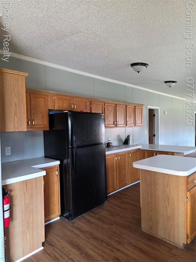 4605 Pleasant St, Clifford, MI 48727 - kitchen featuring freestanding refrigerator, ornamental molding, dark wood-style flooring, brown cabinetry, and a textured ceiling