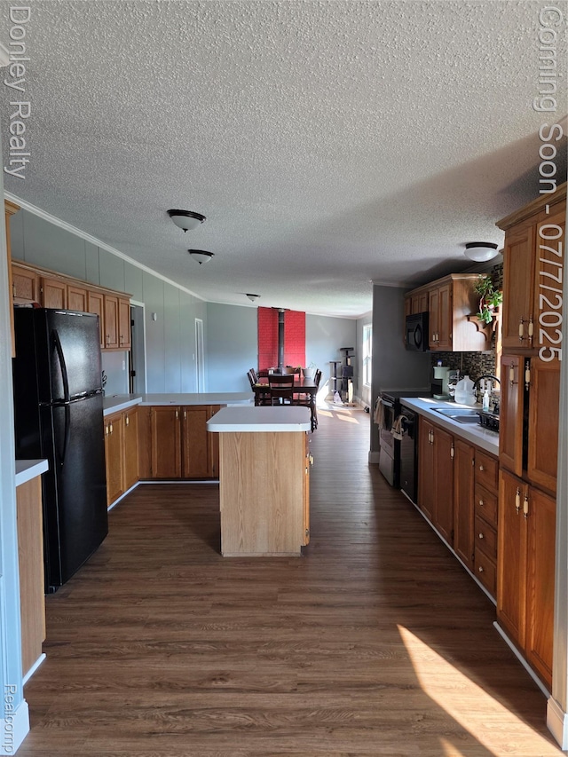 4605 Pleasant St, Clifford, MI 48727 - kitchen featuring black appliances, dark wood-style floors, a textured ceiling, light countertops, and a peninsula