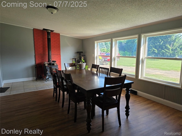 4605 Pleasant St, Clifford, MI 48727 - dining area with crown molding, a wood stove, a textured ceiling, and wood finished floors