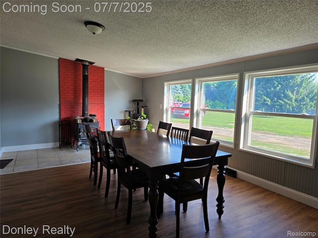 4605 Pleasant St, Clifford, MI 48727 - dining room featuring ornamental molding, a wood stove, wood finished floors, and a textured ceiling