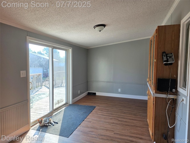4605 Pleasant St, Clifford, MI 48727 - empty room with dark wood-style floors, a textured ceiling, a wainscoted wall, and ornamental molding