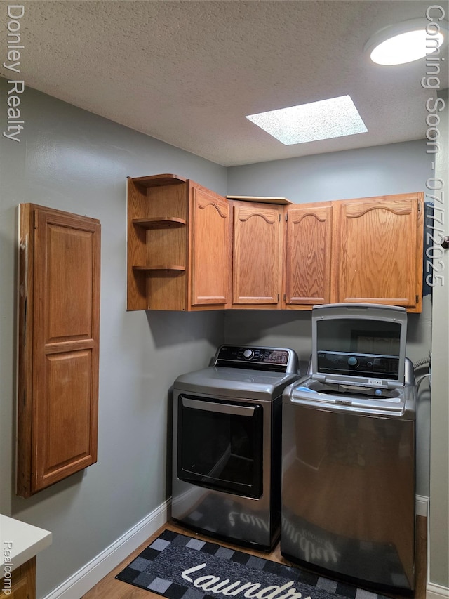 4605 Pleasant St, Clifford, MI 48727 - washroom featuring washing machine and dryer, a skylight, cabinet space, a textured ceiling, and wood finished floors