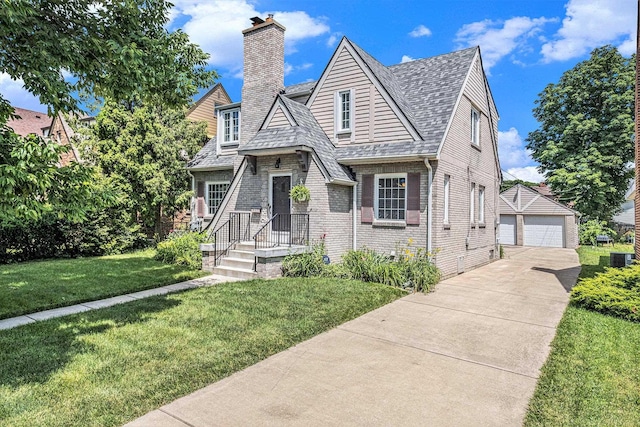927 Kensington Ave, Flint, MI 48503 - view of front of property with a detached garage, a chimney, roof with shingles, an outbuilding, and a front yard