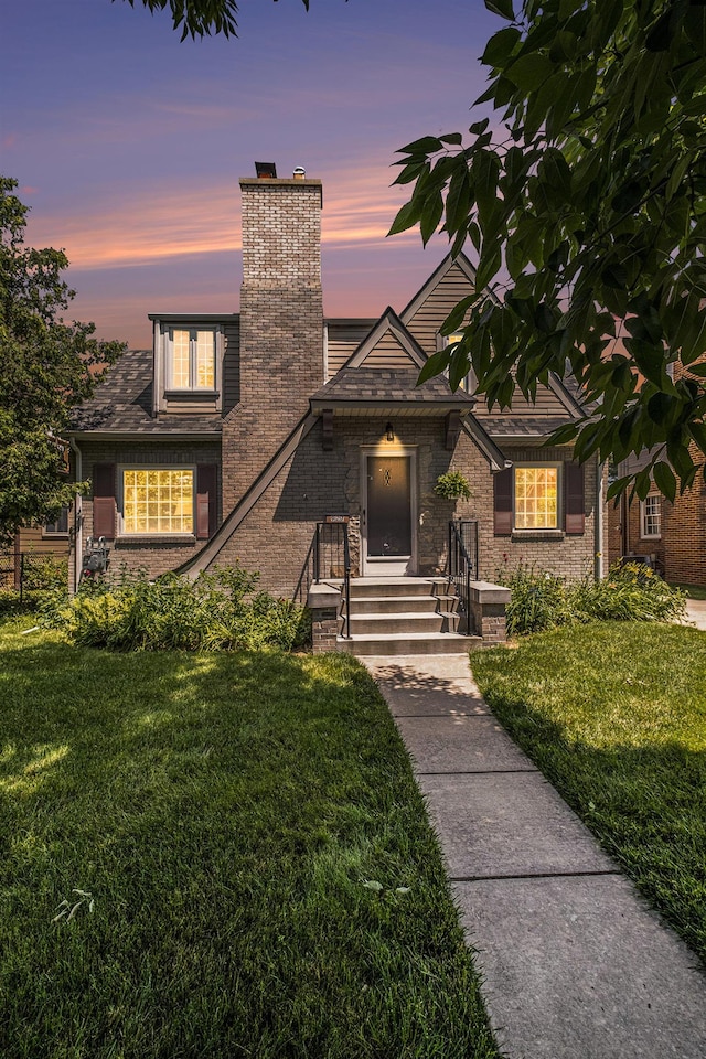 927 Kensington Ave, Flint, MI 48503 - view of front of property with a chimney, a lawn, and brick siding