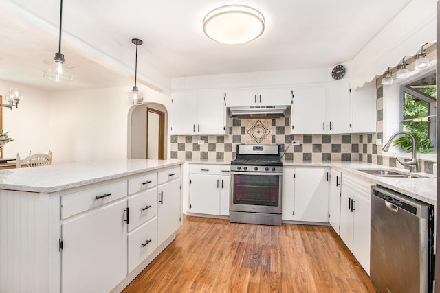 14814 Stone Jug Rd, Battle Creek, MI 49015 - kitchen with stainless steel appliances, under cabinet range hood, tasteful backsplash, and arched walkways