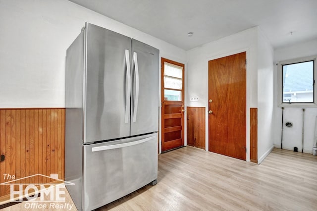 1114 Lynn St, Owosso, MI 48867 - kitchen featuring freestanding refrigerator, wainscoting, wood walls, and wood finished floors