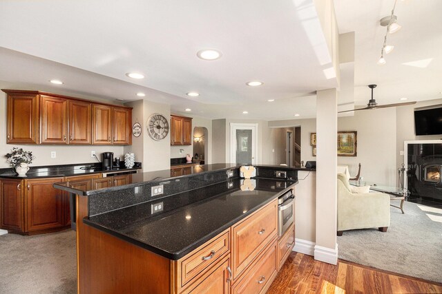 9991 Kaiser Rd, Saline, MI 48176 - kitchen with open floor plan, recessed lighting, brown cabinets, stainless steel oven, and dark stone countertops