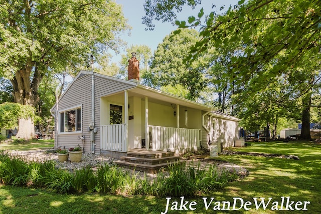 2338 Edgewood Dr, Kalamazoo, MI 49008 - view of front of home with a front yard, a chimney, and a porch