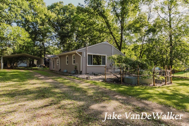 2338 Edgewood Dr, Kalamazoo, MI 49008 - back of property featuring a lawn, a carport, and a garden