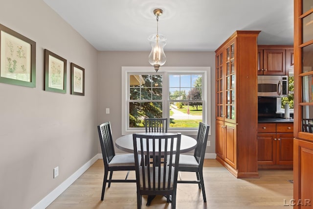 144 N Scott St, Adrian, MI 49221 - dining space with light wood-type flooring and baseboards