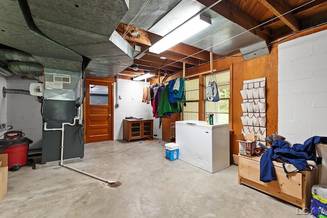 144 N Scott St, Adrian, MI 49221 - below grade area featuring refrigerator, heating unit, and concrete block wall