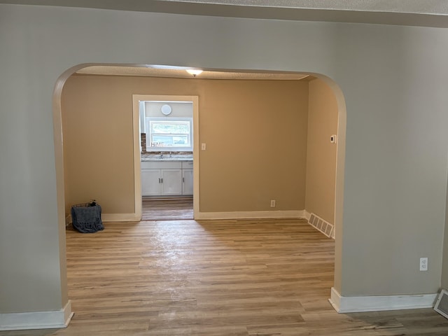 2233 Mc Ilwraith St, Muskegon Heights, MI 49444 - unfurnished room with arched walkways and light wood-type flooring