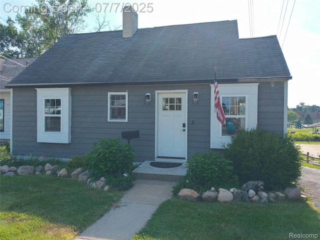 501 N Leroy St, Fenton, MI 48430 - cape cod home featuring a chimney and a front yard
