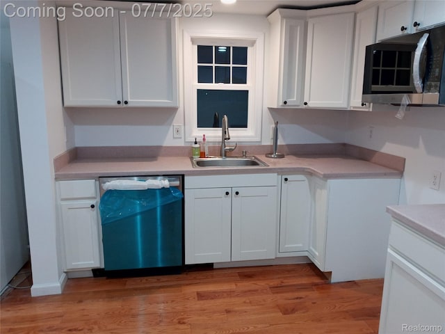 501 N Leroy St, Fenton, MI 48430 - kitchen with dishwasher, stainless steel microwave, white cabinetry, light countertops, and light wood-type flooring