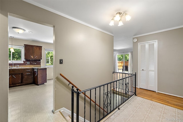 26250 Virginia Dr, Warren, MI 48091 - hall featuring an upstairs landing, crown molding, and light wood-style flooring