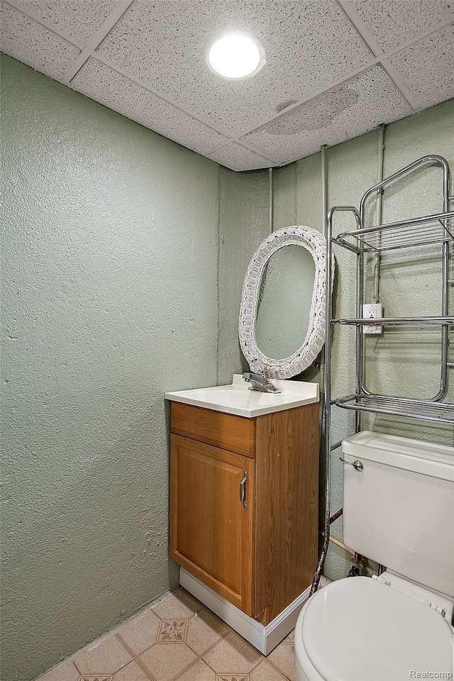 26250 Virginia Dr, Warren, MI 48091 - bathroom featuring vanity, a drop ceiling, a textured wall, and tile patterned floors