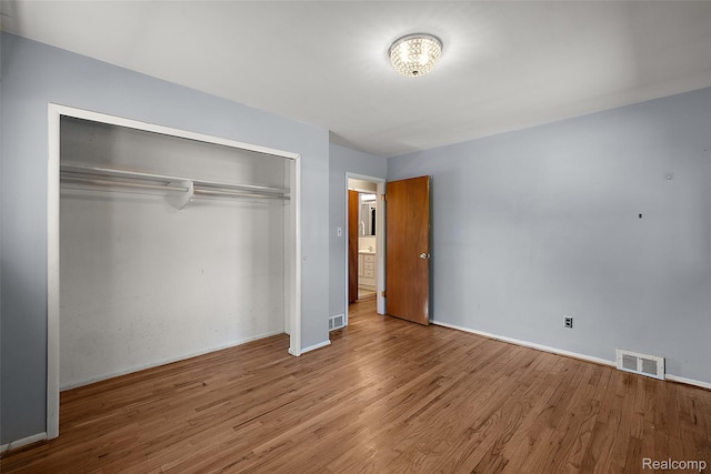 26250 Virginia Dr, Warren, MI 48091 - unfurnished bedroom with a closet, wood finished floors, and a chandelier