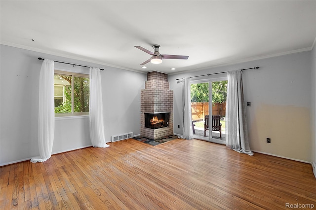 26250 Virginia Dr, Warren, MI 48091 - unfurnished living room featuring light wood-style flooring, a ceiling fan, healthy amount of natural light, ornamental molding, and a fireplace