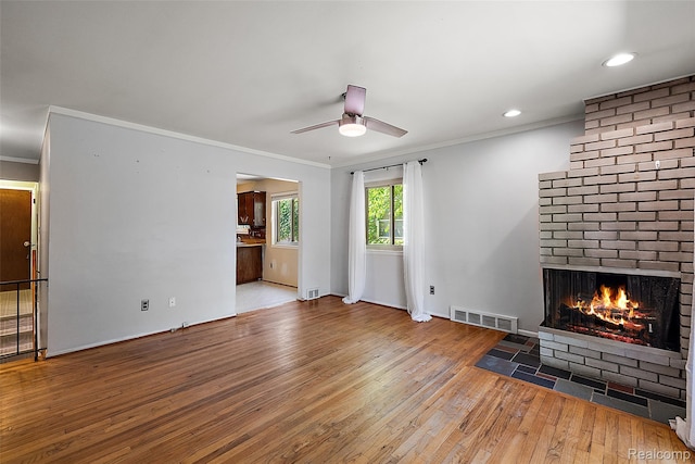 26250 Virginia Dr, Warren, MI 48091 - unfurnished living room with wood-type flooring, ornamental molding, a brick fireplace, a ceiling fan, and recessed lighting