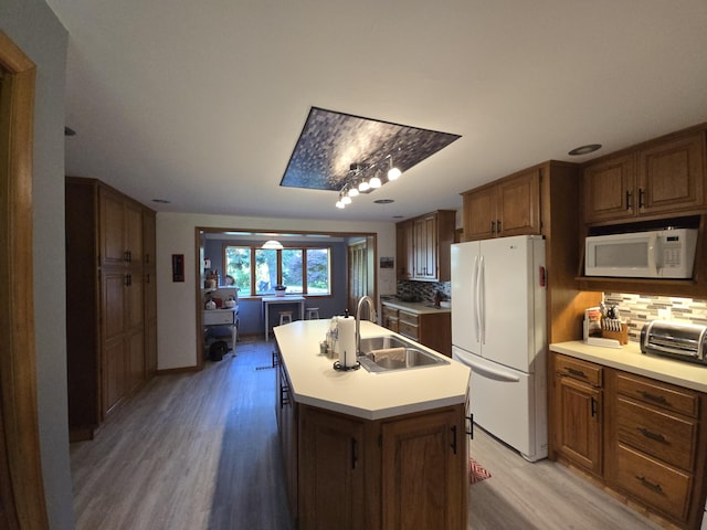 971 Weaver Rd, Bronson, MI 49028 - kitchen with white appliances, light wood-style floors, tasteful backsplash, light countertops, and a center island with sink