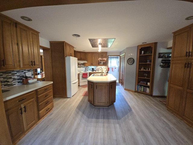 971 Weaver Rd, Bronson, MI 49028 - kitchen with white appliances, brown cabinets, light wood-type flooring, and tasteful backsplash