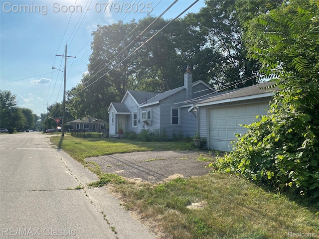 18404 Deering St, Livonia, MI 48152 - view of front of house with a chimney, a garage, and a front yard