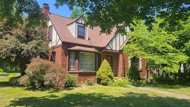 401 Budlong St, Adrian, MI 49221 - english style home featuring brick siding, a front yard, and a chimney
