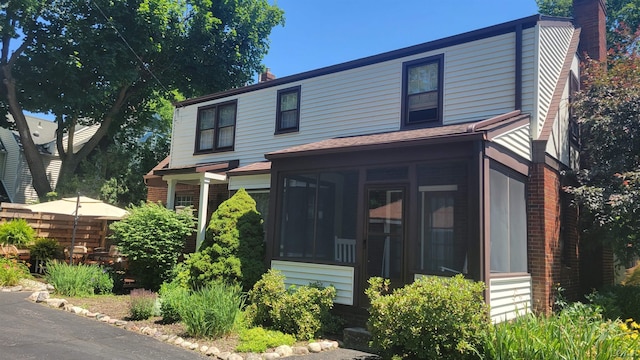 401 Budlong St, Adrian, MI 49221 - view of front of home featuring a chimney, a sunroom, and a shingled roof