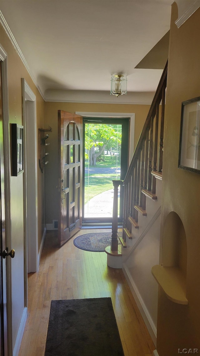 401 Budlong St, Adrian, MI 49221 - foyer entrance with light wood-type flooring, stairway, and crown molding