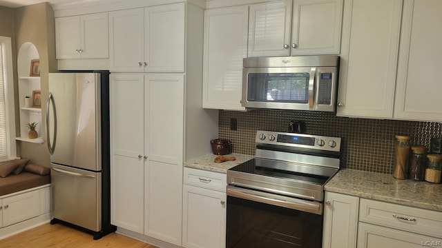401 Budlong St, Adrian, MI 49221 - kitchen with appliances with stainless steel finishes, tasteful backsplash, white cabinetry, and light stone countertops