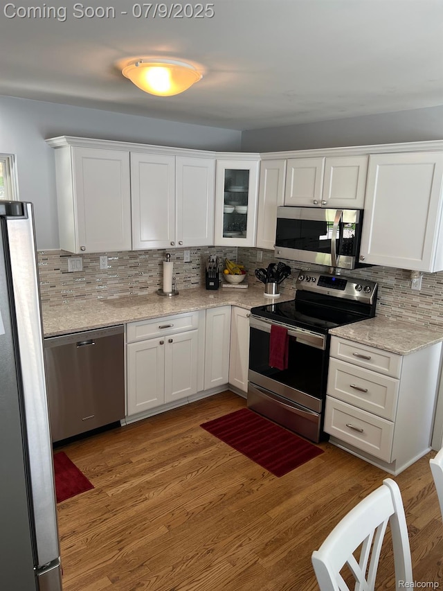 5348 Forest Ridge Dr, Clarkston, MI 48346 - kitchen featuring stainless steel appliances, tasteful backsplash, white cabinets, light wood-style floors, and glass insert cabinets