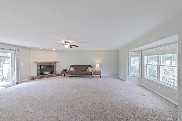 9100 Mayfred Dr, Pinckney, MI 48169 - living area featuring healthy amount of natural light, carpet flooring, a brick fireplace, and a ceiling fan