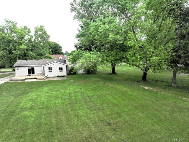 9100 Mayfred Dr, Pinckney, MI 48169 - view of green lawn featuring a wooden deck