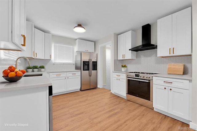 3992 Devonshire Rd, Detroit, MI 48224 - kitchen with wall chimney range hood, appliances with stainless steel finishes, light wood finished floors, tasteful backsplash, and white cabinetry