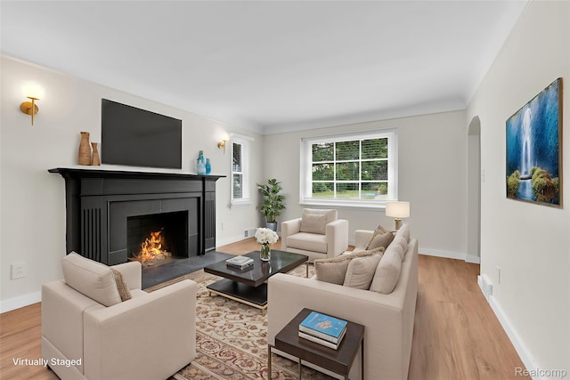 3992 Devonshire Rd, Detroit, MI 48224 - living room with light wood finished floors, a fireplace with flush hearth, and arched walkways