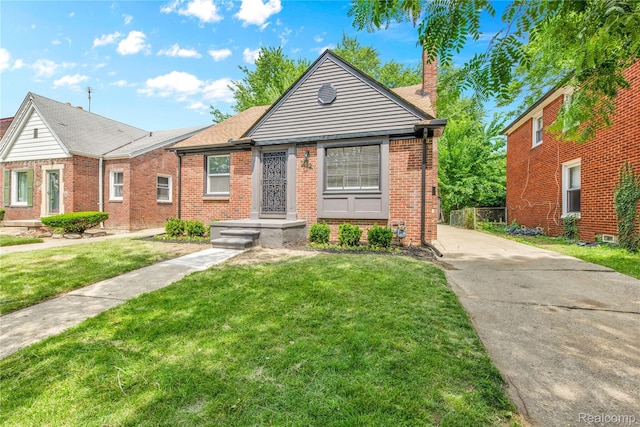 3992 Devonshire Rd, Detroit, MI 48224 - view of front of property featuring brick siding, a front lawn, and a chimney
