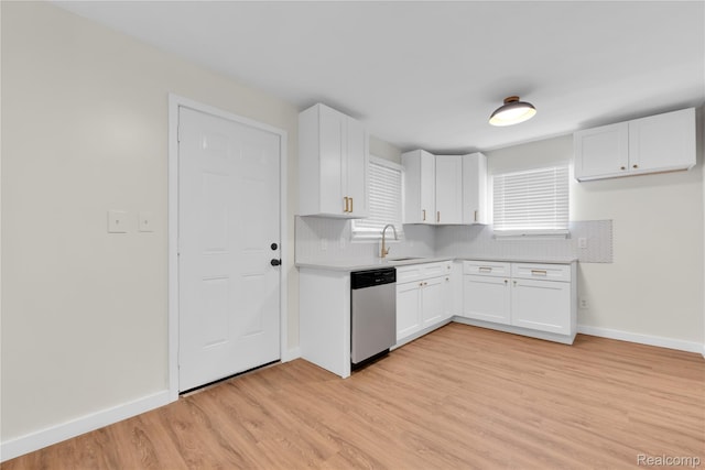 3992 Devonshire Rd, Detroit, MI 48224 - kitchen with dishwasher, light wood-style flooring, light countertops, white cabinetry, and decorative backsplash