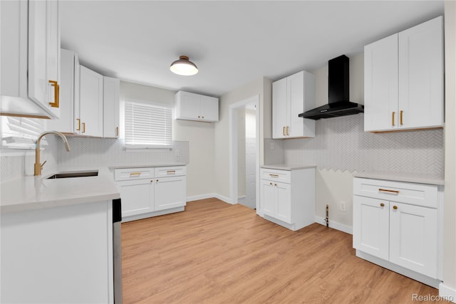 3992 Devonshire Rd, Detroit, MI 48224 - kitchen featuring wall chimney exhaust hood, backsplash, light wood-style floors, and white cabinets