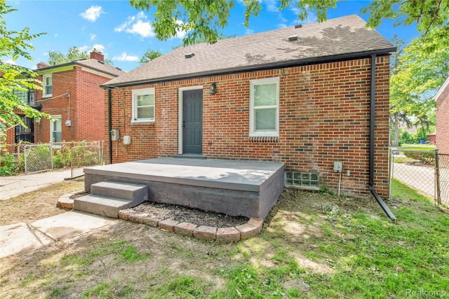 3992 Devonshire Rd, Detroit, MI 48224 - rear view of property featuring brick siding, a chimney, and roof with shingles