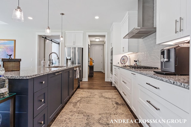 2063 Ottawa Beach Rd, Holland, MI 49424 - kitchen with wall chimney range hood, white cabinetry, tasteful backsplash, light stone counters, and recessed lighting
