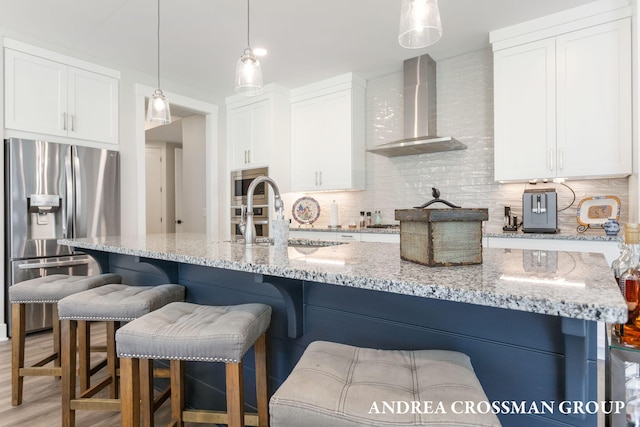 2063 Ottawa Beach Rd, Holland, MI 49424 - kitchen featuring stainless steel appliances, wall chimney range hood, decorative backsplash, and white cabinetry