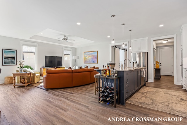 2063 Ottawa Beach Rd, Holland, MI 49424 - living area featuring a raised ceiling, wood finished floors, recessed lighting, and a ceiling fan