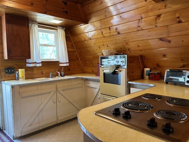 3423 S James Rd, Baldwin, MI 49304 - kitchen with oven, light countertops, wooden walls, electric stovetop, and white cabinets