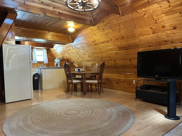 3423 S James Rd, Baldwin, MI 49304 - dining area with beam ceiling, wooden walls, and light wood-style floors